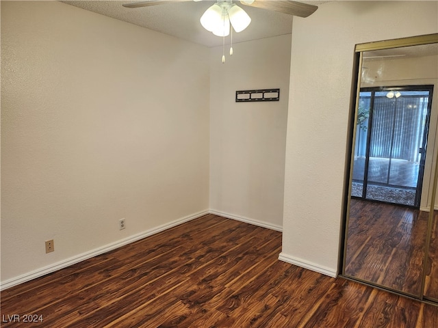 empty room with a textured ceiling, ceiling fan, and dark wood-type flooring