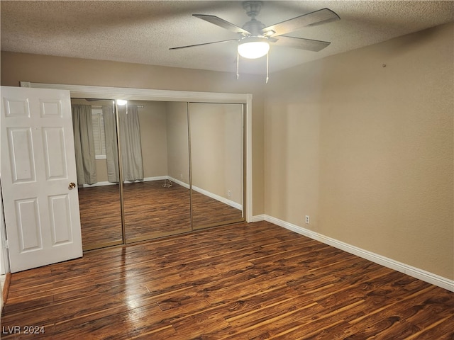 unfurnished bedroom featuring a textured ceiling, a closet, ceiling fan, and dark wood-type flooring