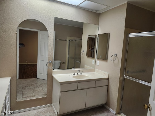 bathroom with vanity, toilet, and an enclosed shower