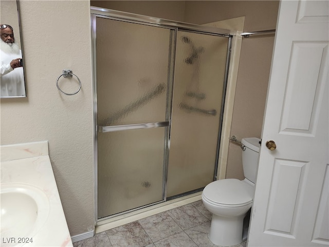 bathroom with vanity, toilet, and an enclosed shower