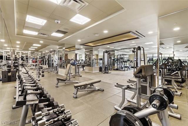 exercise room featuring a drop ceiling and a tray ceiling