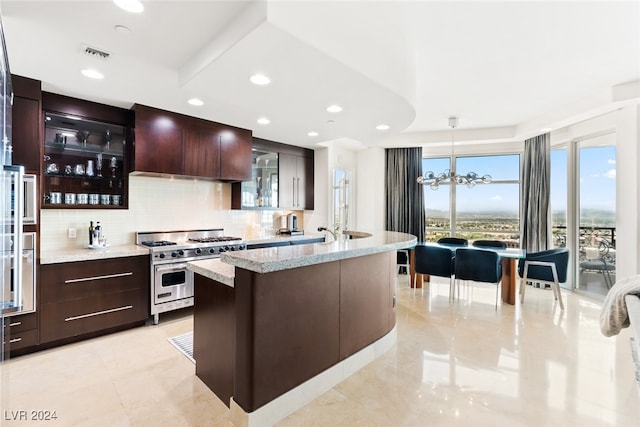 kitchen featuring custom range hood, decorative light fixtures, a chandelier, appliances with stainless steel finishes, and tasteful backsplash