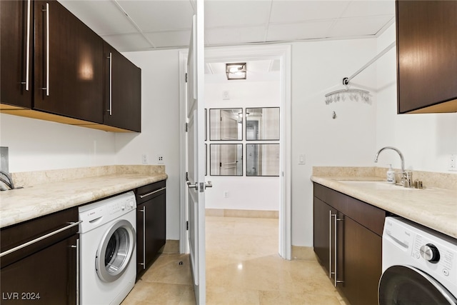 clothes washing area featuring sink, light tile patterned flooring, washer / clothes dryer, and cabinets