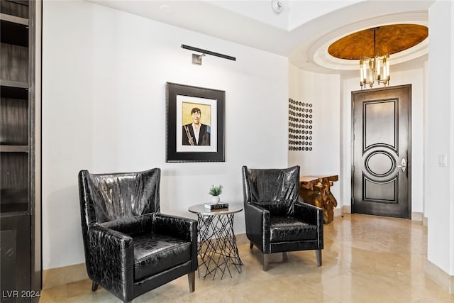 sitting room with a chandelier and a tray ceiling