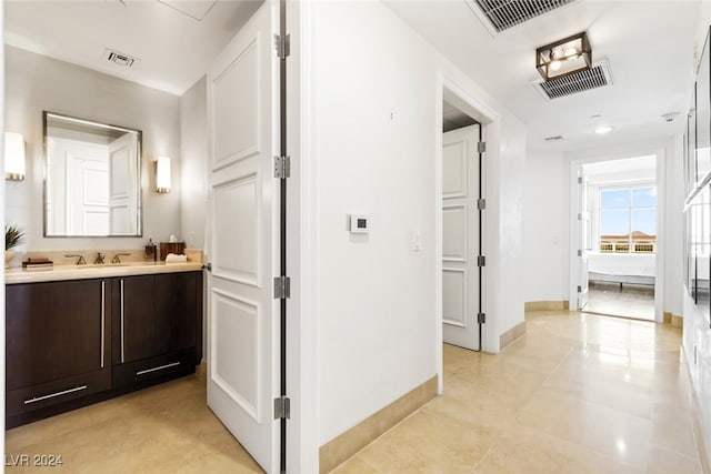 corridor featuring light tile patterned flooring and sink