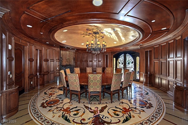 dining space with ornamental molding, a chandelier, and wooden walls