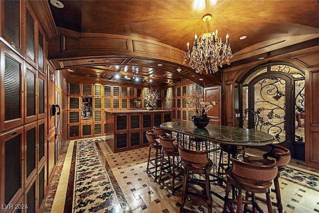 wine cellar featuring wood walls, lofted ceiling, and an inviting chandelier