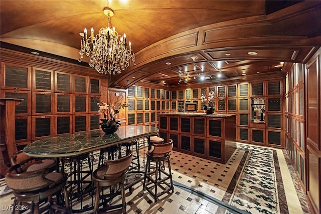 wine cellar featuring lofted ceiling and an inviting chandelier