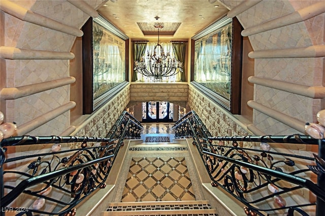 staircase with a chandelier