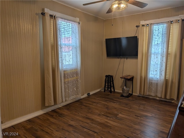 unfurnished living room featuring ornamental molding, dark wood-type flooring, and ceiling fan