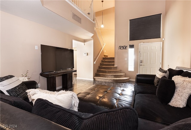 living room featuring light tile patterned flooring and a high ceiling