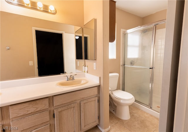 bathroom featuring vanity, toilet, a shower with shower door, and tile patterned flooring