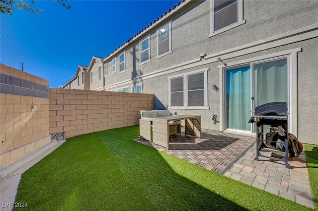 rear view of property featuring a yard and a patio