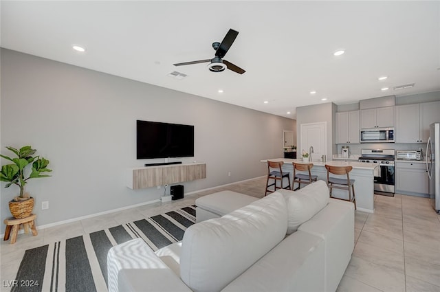 tiled living room featuring ceiling fan