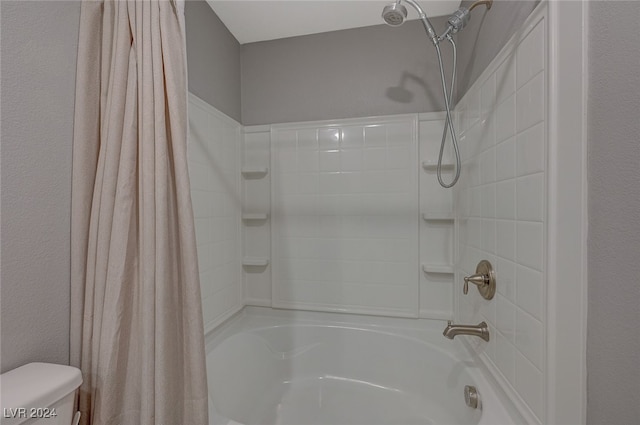 bathroom featuring shower / bath combo and toilet