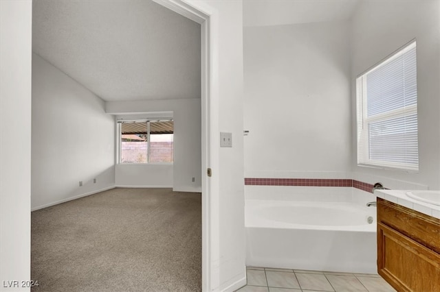 bathroom featuring vanity, tile patterned floors, and a washtub