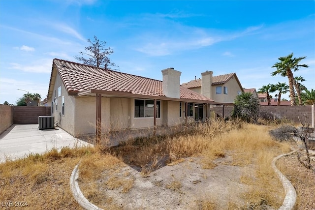 back of property with central air condition unit and a patio area