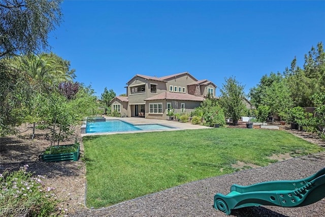 back of house with a patio and a lawn