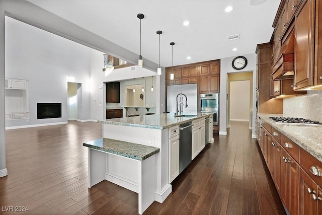 kitchen featuring white cabinets, stainless steel appliances, light stone counters, and dark wood-type flooring