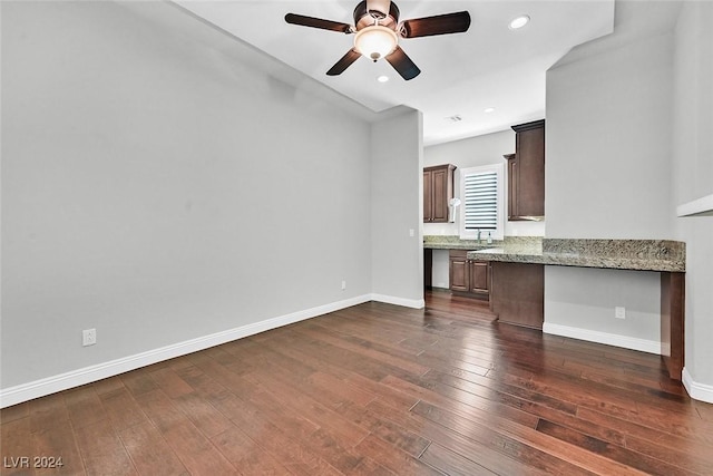 unfurnished living room featuring ceiling fan, sink, and dark wood-type flooring