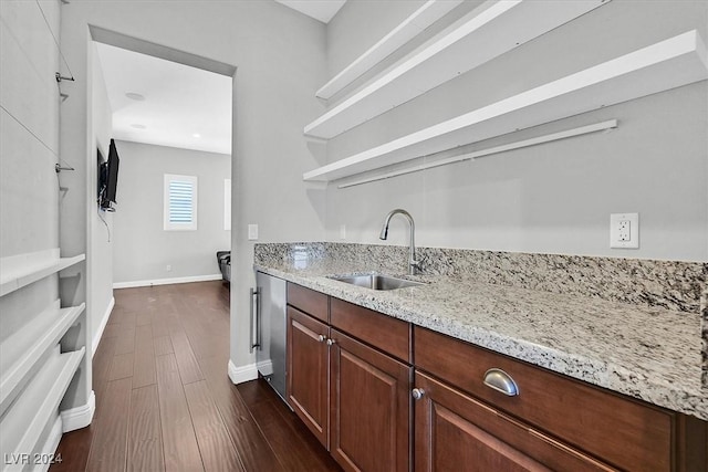 kitchen with light stone counters, sink, and dark wood-type flooring