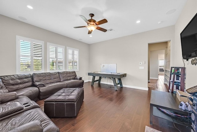 living room featuring ceiling fan and dark wood-type flooring