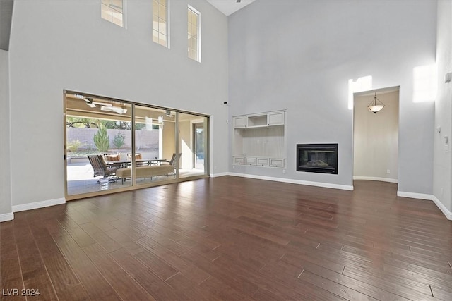 unfurnished living room with dark hardwood / wood-style flooring and a high ceiling