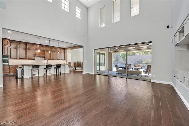 unfurnished living room with dark hardwood / wood-style flooring and a high ceiling