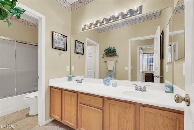 full bathroom featuring vanity, enclosed tub / shower combo, toilet, and tile patterned floors