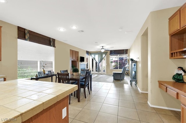 dining room with ceiling fan, light tile patterned floors, and plenty of natural light