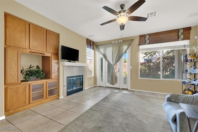 tiled living room featuring a tiled fireplace and ceiling fan