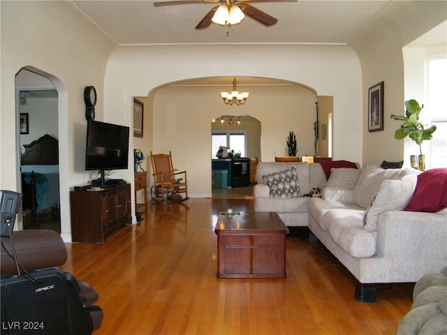 living room with hardwood / wood-style floors and ceiling fan with notable chandelier