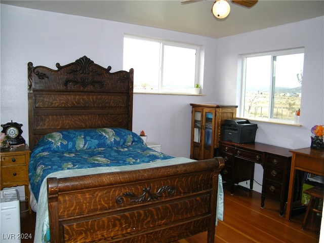 bedroom featuring multiple windows, hardwood / wood-style flooring, and ceiling fan