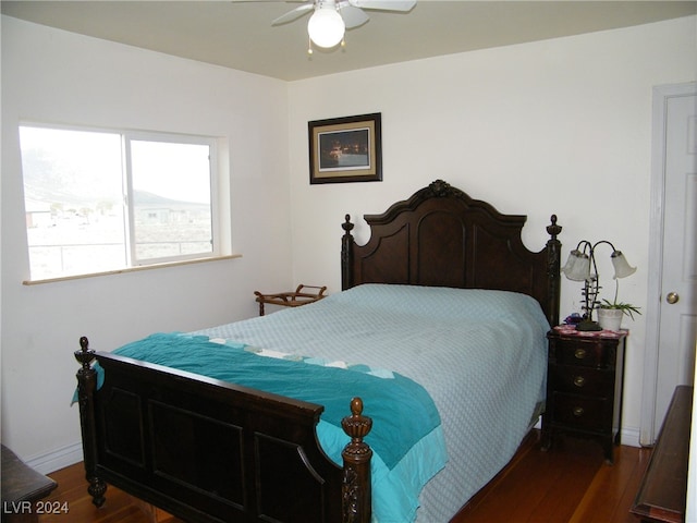 bedroom with dark hardwood / wood-style flooring and ceiling fan