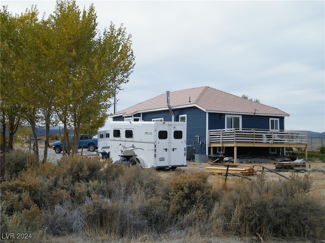 rear view of house featuring a wooden deck