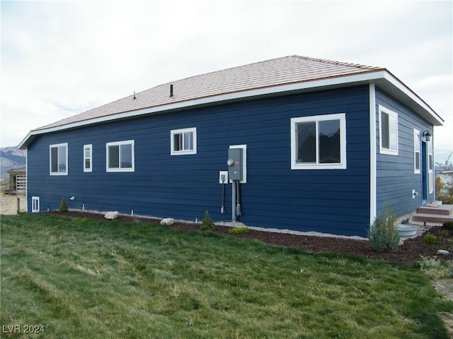 rear view of house featuring a lawn