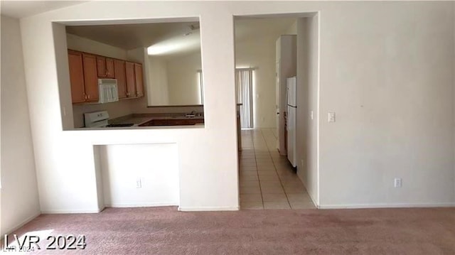 kitchen featuring light colored carpet and white appliances