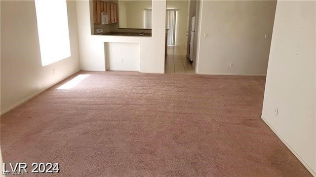 unfurnished living room featuring light carpet