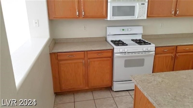 kitchen featuring light tile patterned floors and white appliances