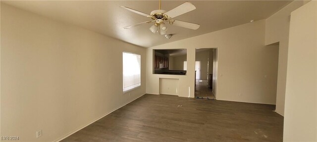 spare room featuring dark wood-type flooring, vaulted ceiling, and ceiling fan