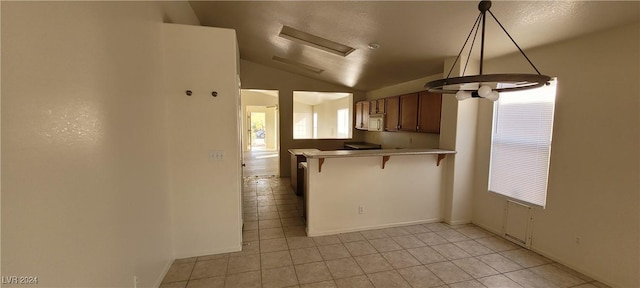 kitchen featuring pendant lighting, a kitchen breakfast bar, a textured ceiling, vaulted ceiling, and kitchen peninsula