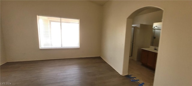 unfurnished room with dark wood-type flooring