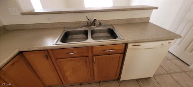 kitchen featuring dishwasher, sink, and light tile patterned flooring