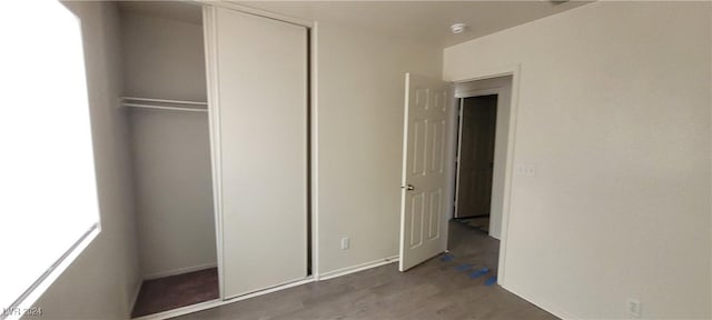 unfurnished bedroom featuring a closet and dark hardwood / wood-style floors