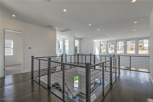 hall featuring visible vents, hardwood / wood-style floors, and an upstairs landing