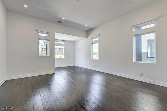 empty room with recessed lighting, dark wood-style flooring, visible vents, and baseboards