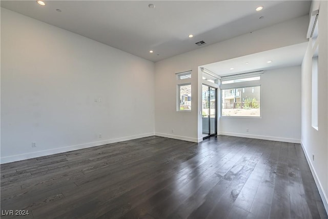 empty room featuring baseboards, visible vents, dark wood-style flooring, and recessed lighting