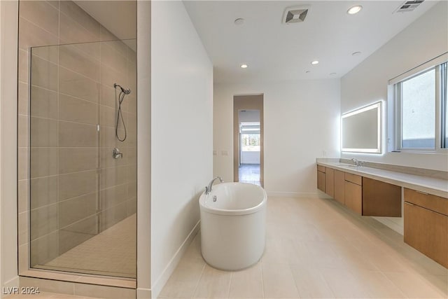 full bathroom with vanity, a soaking tub, a tile shower, and visible vents