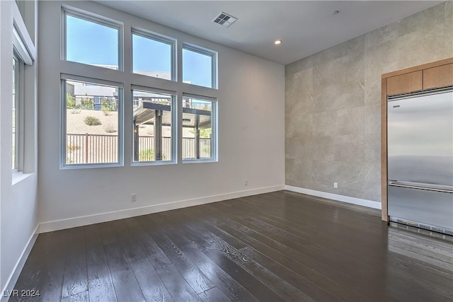 empty room featuring dark wood-type flooring, recessed lighting, visible vents, and baseboards