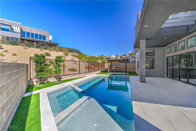 view of swimming pool with a patio, a fenced backyard, and a pool with connected hot tub